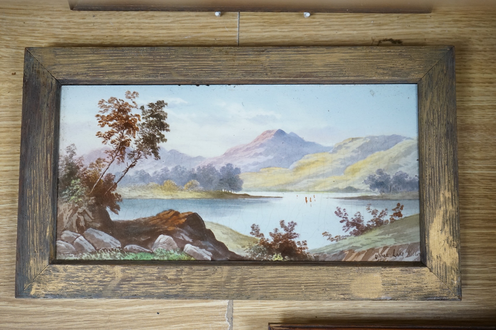 Four ceramic painted plaques depicting landscapes to include ‘Upper Lake Killard’, three framed, largest 36cm wide